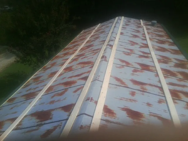 Rusted metal roof panels with new wood purlins before replacement — Storm Damage Roof Repair in Roopville by Roofing Brothers