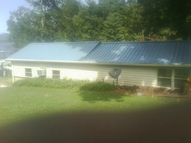 Blue metal roof running the length of a single story home in Roopville